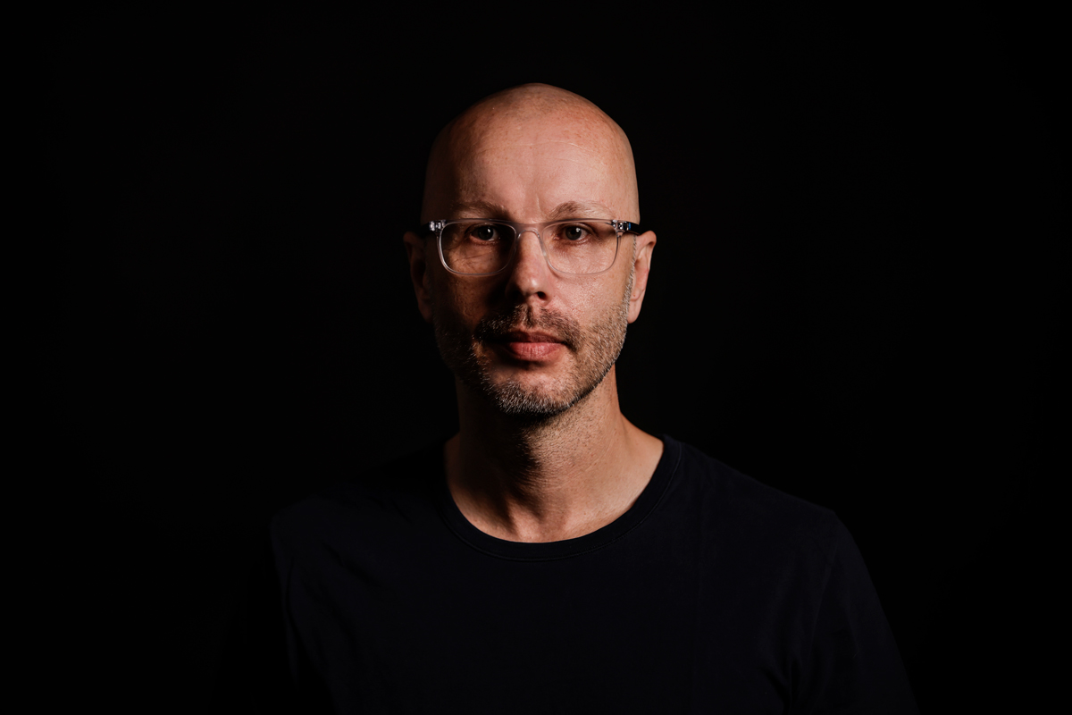 Portraitfoto von Axel Hillebrandt - Gesicht auf schwarzem Hintergrund.